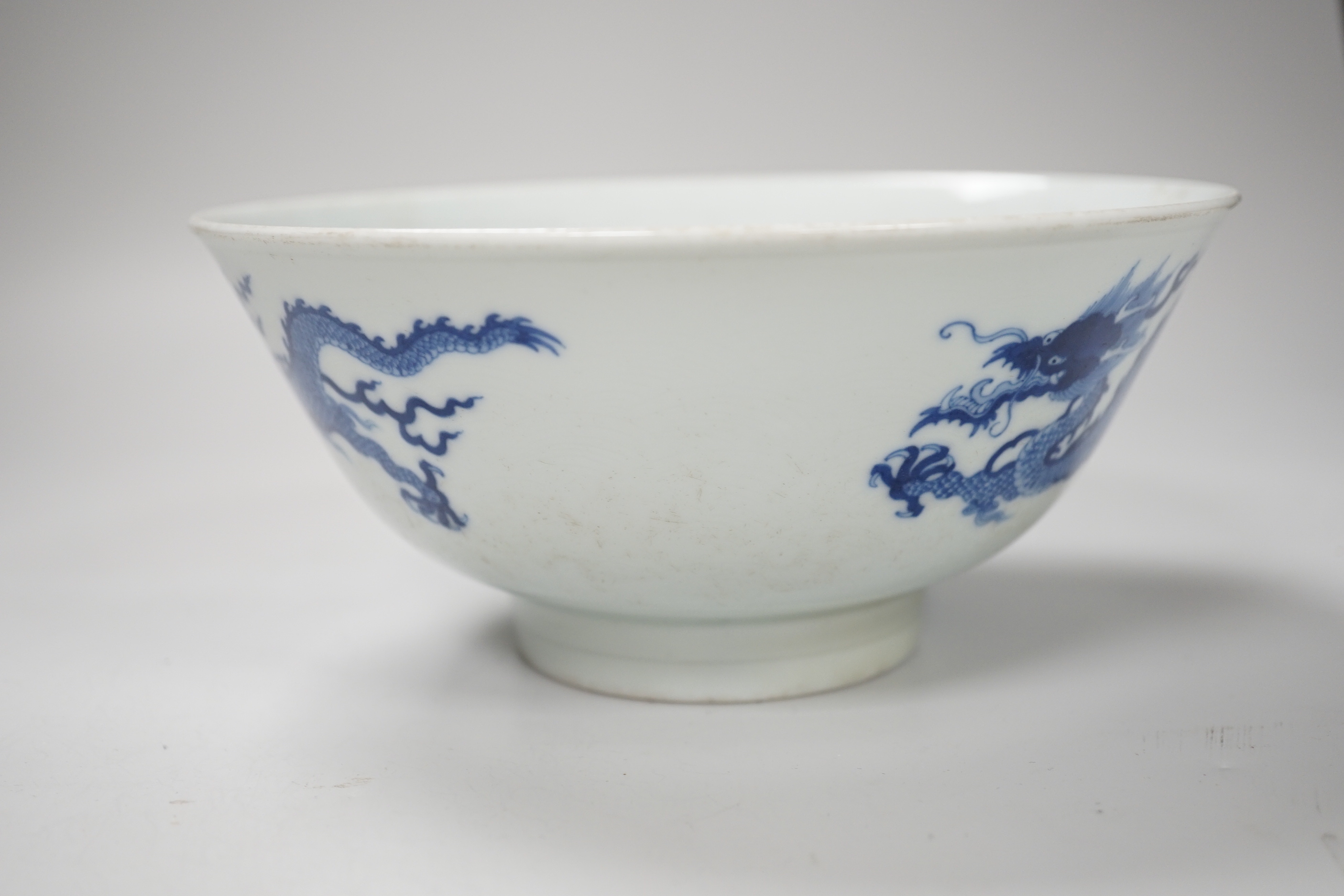 A Chinese blue and white bowl, hand painted with dragons, housed in a fitted case, 18cm in diameter